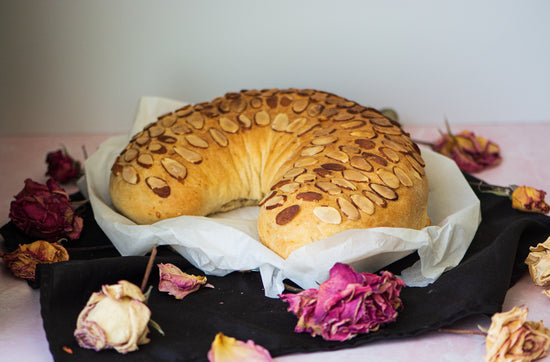 Image of stuffed bread placed on top of parchment paper, surrounded by floral decorations.