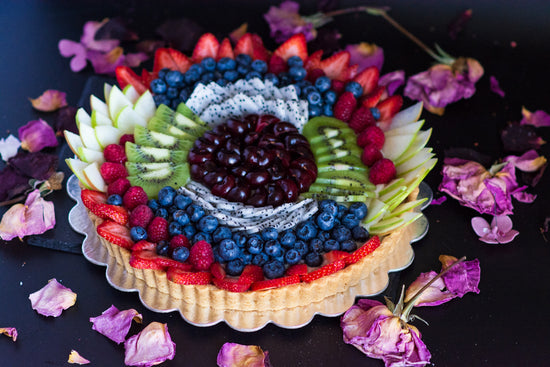 Image of tart topped with colorful arrangement of sliced fruit.