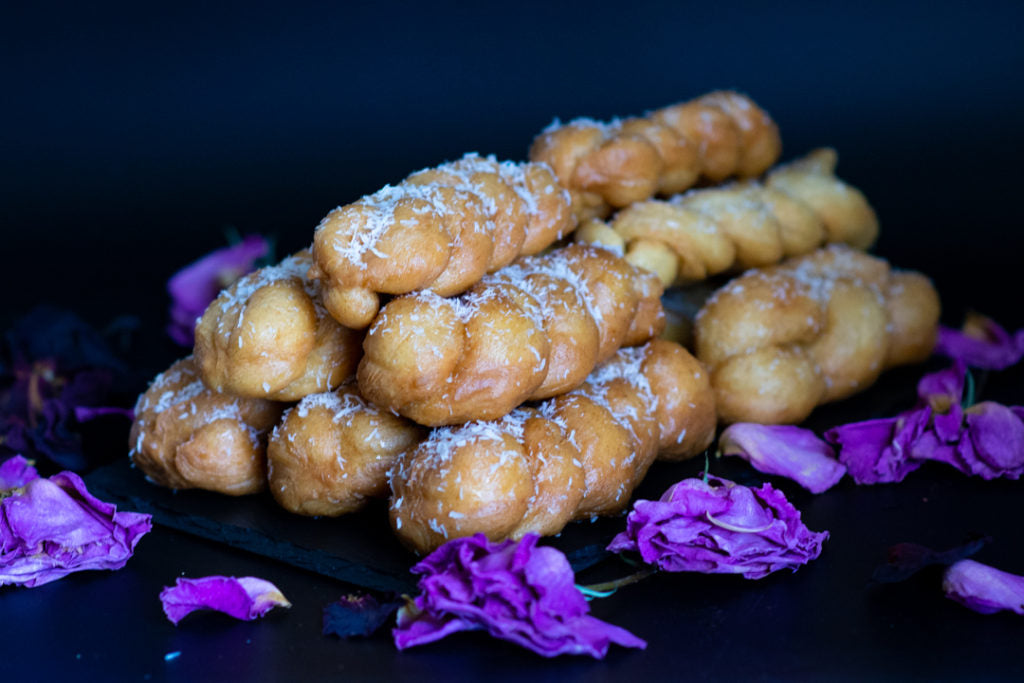 Image of stacked braided desserts, surrounded by floral decorations.