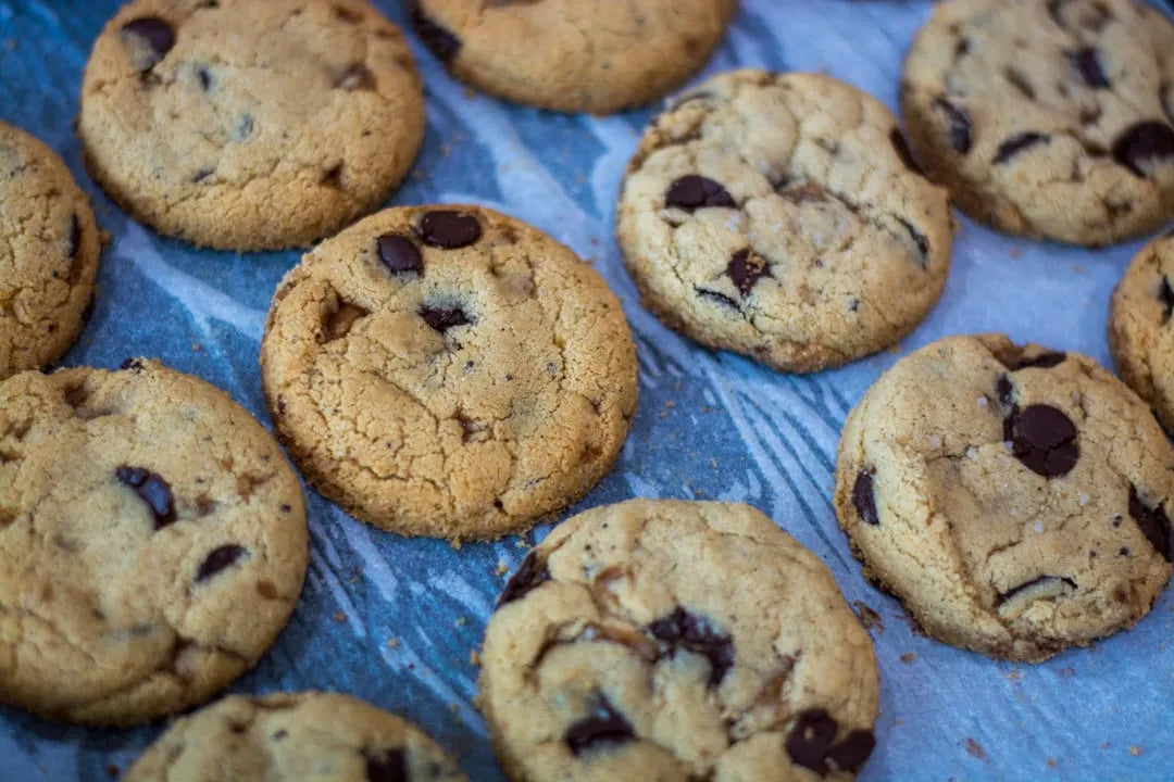 Several gluten-Free chocolate chip cookies on a flat surface.