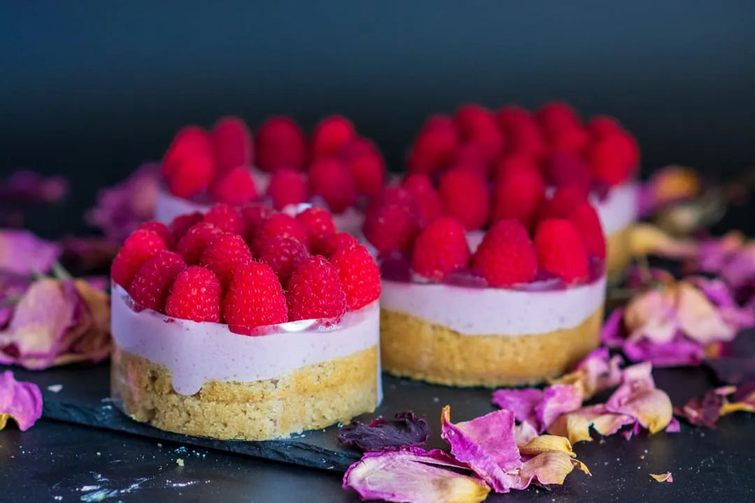 Chipper & Cheeky luxury gluten-free raspberry mousse mini cake for a gala in Orange County showing a detailed cross-section of vanilla sponge cake, fresh raspberry-rose compote, and delicate rose cream layers for celiac-safe event catering in Los Angeles.